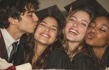 Four graduates in a close group hug